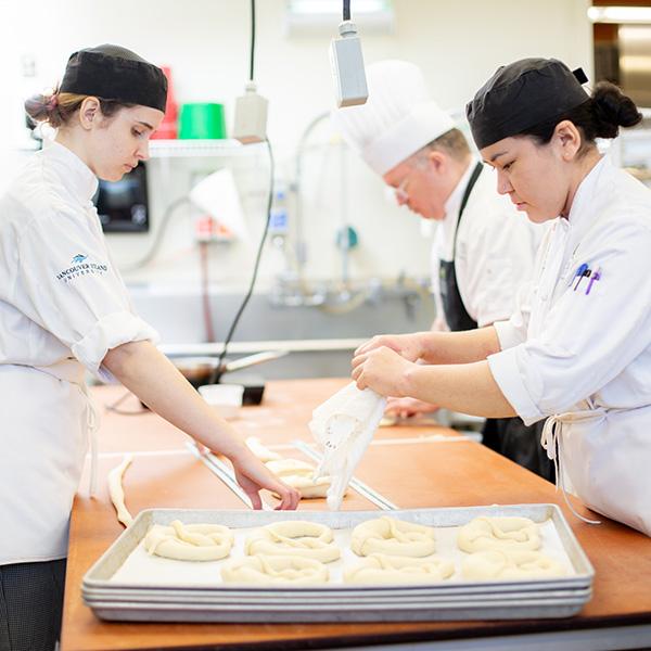 Three baking students working at a counter. 
