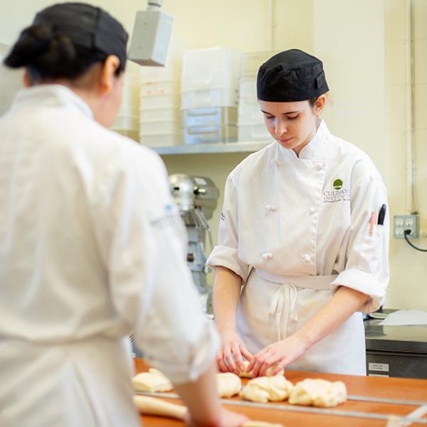 Two baking students working at a table. 