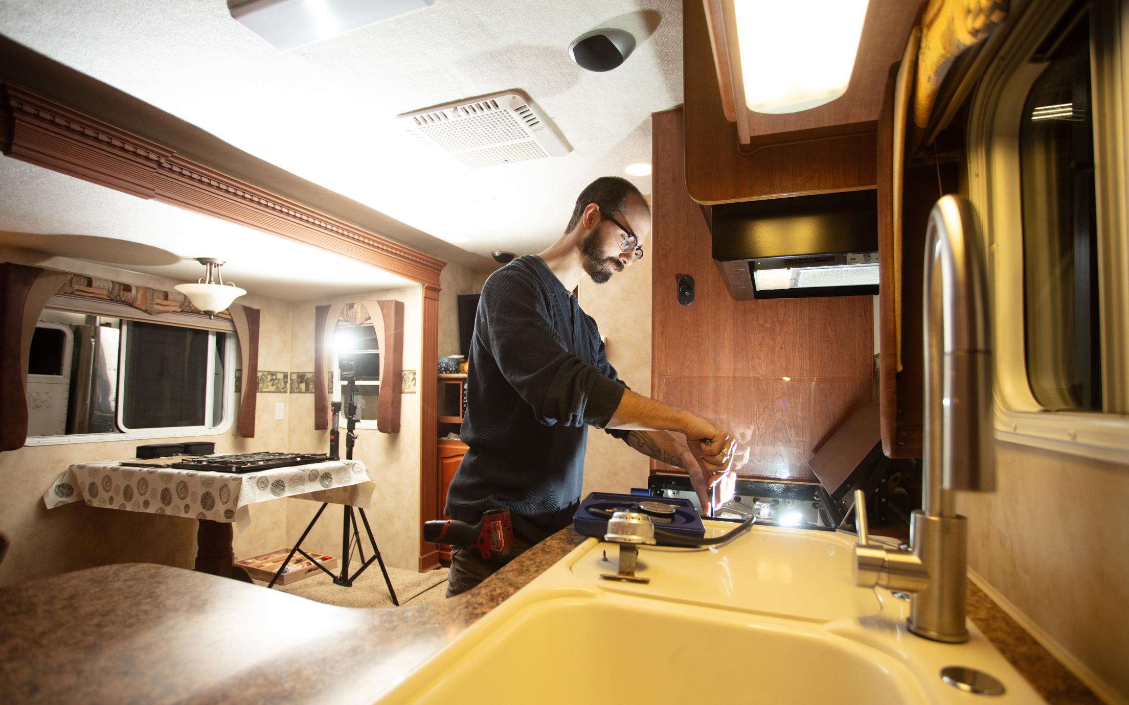 A man working on the inside of a recreational vehicle. 